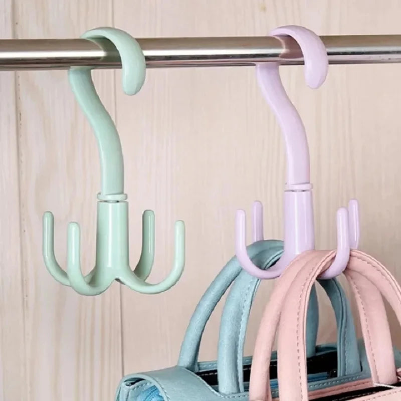 Three pastel colored multi-functional hanging hooks are displayed on a metal bar.