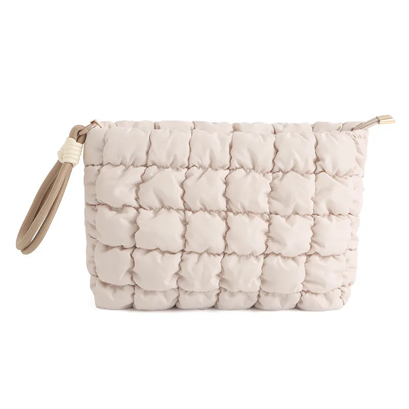 A light beige quilted puffer makeup bag with a drawstring closure.