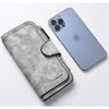 A silver gray leather long zipper handbag coin purse next to a light blue smartphone.
