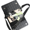 A black plaid crossbody shoulder bag with a large capacity, featuring a canvas texture and various accessories inside.