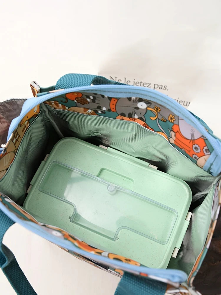 Bolsa térmica estampada en verde azulado y naranja con contenedor de plástico transparente interior.