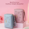 A pink multifunction fashion wallet with a zipper closure and decorative floral pattern is displayed on a light pink surface.