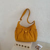 A mustard yellow plaid nylon drawstring tote bag resting on a light surface.