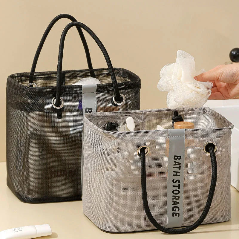 Un organizador de bolsa de ducha de malla gris con asas negras junto a un accesorio de baño blanco.