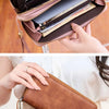 A close-up of a leopard print RFID-blocking tri-fold wallet in brown leather being held by a hand.