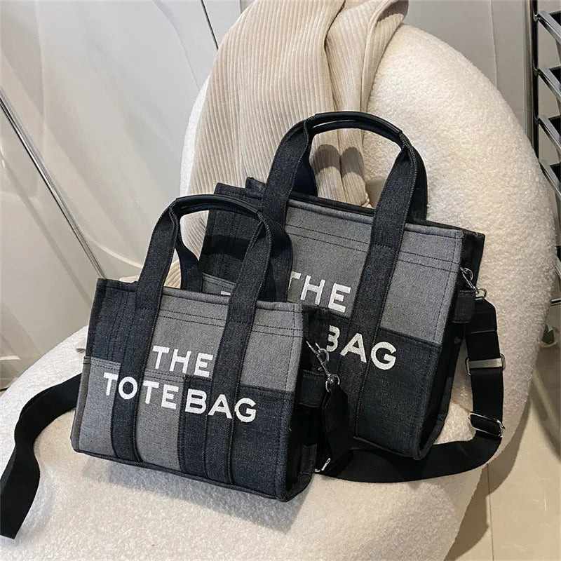 A black and gray tote bag with handles is displayed on a light-colored surface.