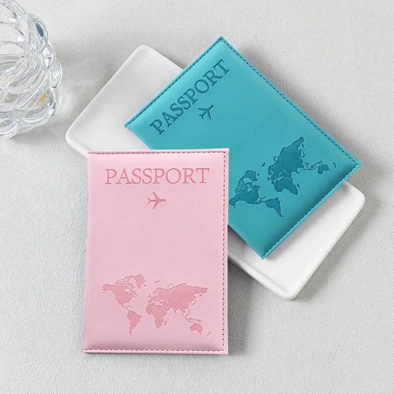 Deux passeports, un bleu sarcelle et un rose, sont exposés sur une surface claire.