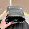 A dark gray luxury rhinestone evening clutch bag is held by a hand against a light background.
