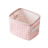 A pink checkered storage basket made of cotton linen for desk organization.
