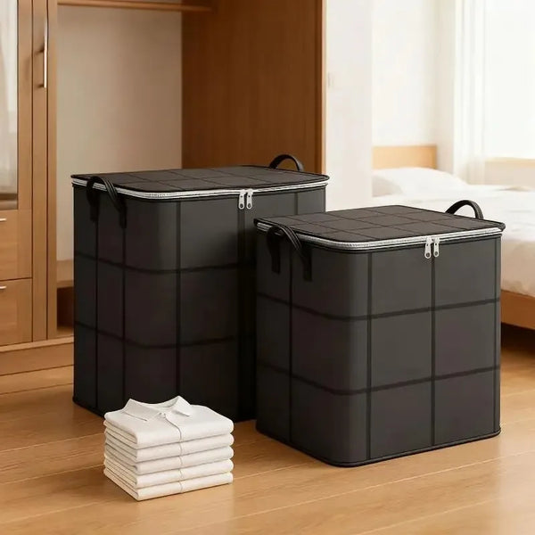 Two large black foldable storage organizer bags standing on a wooden floor next to a stack of white folded shirts.