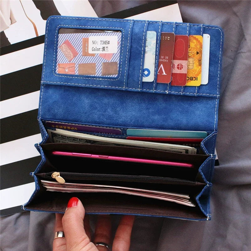 A blue leather clutch wallet is shown open, displaying various cards and cash inside.
