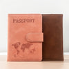 A tan leather passport wallet with a brown sleeve and a world map design.