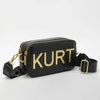 Black leather pouch bag with gold lettering and a black strap