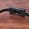 Porte-clés de téléphone en cuir noir sur un support en bois foncé.