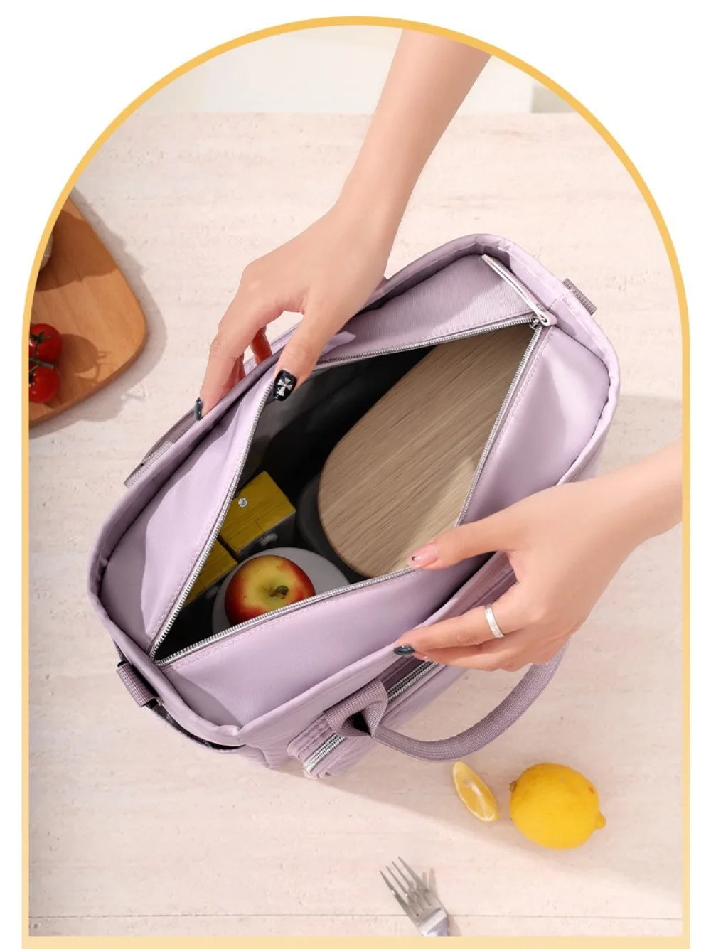 A hand is opening a purple insulated lunch bag to show its interior, with a lemon nearby.