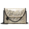 A vintage gold-toned faux leather flap crossbody bag with a black chain strap.