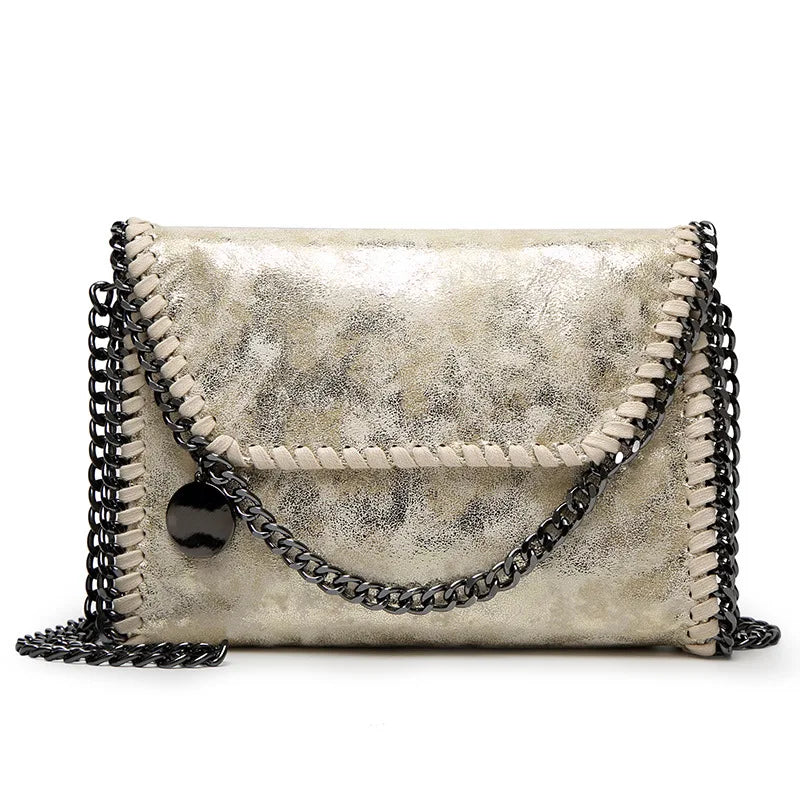A vintage gold-toned faux leather flap crossbody bag with a black chain strap.