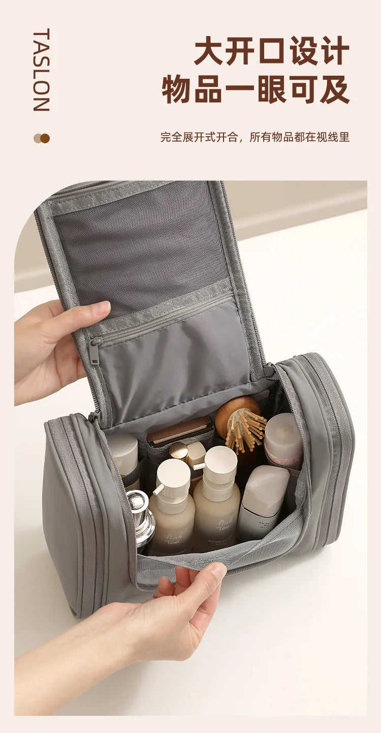 A gray waterproof hanging toiletry bag is open, displaying various skincare and cosmetic products inside.