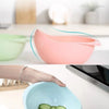 A light blue plastic drain and storage basket filled with sliced cucumbers.