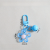 A light blue resin flower keychain attached to a silver-colored split ring.