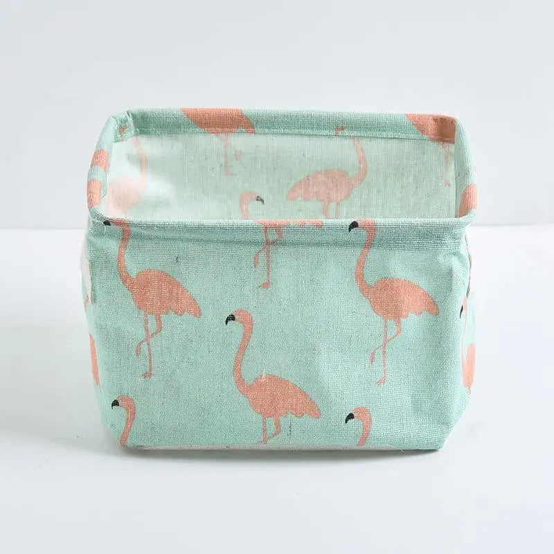A light mint green storage basket with a repeating pattern of pink flamingos for desk organization.