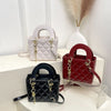 A collection of three quilted handbags in white, red, and black with gold chain accents displayed on a white surface.