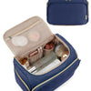 A navy blue cosmetic organizer bag with a quilted pattern is shown open, revealing makeup products and a compact case.