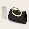 A black elegant women's clutch purse with a gold-toned handle next to a white smartphone.
