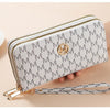 A light gray patterned double zipper wallet with a gold monogram and a leather strap.