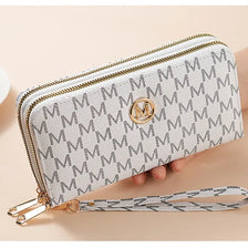 A light gray patterned double zipper wallet with a gold monogram and a leather strap.