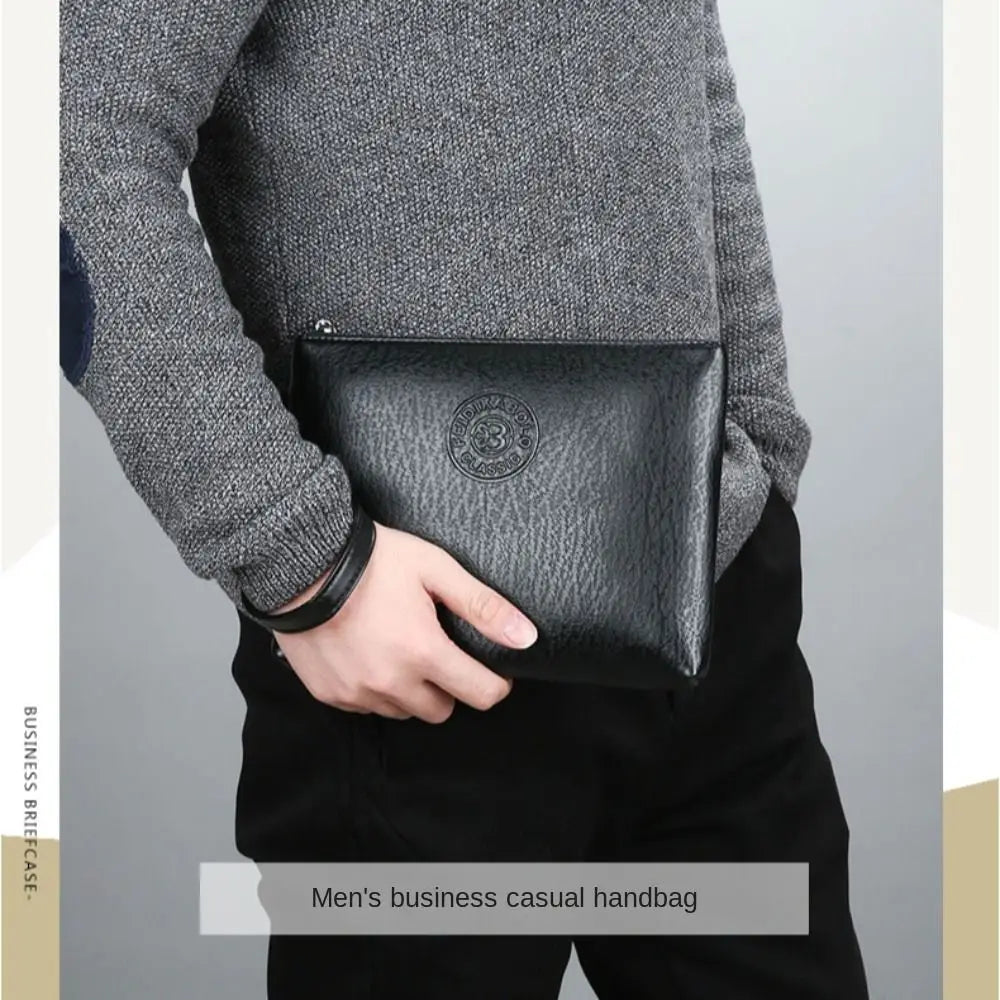A close-up of a man wearing a grey sweater and black pants, holding a black PU leather business casual handbag.