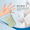 A light green ladies zip coin purse with a key ring hanging from it, shown next to a hand.