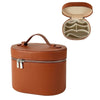 A brown leather travel makeup organizer with a zipper closure, shown closed and open.
