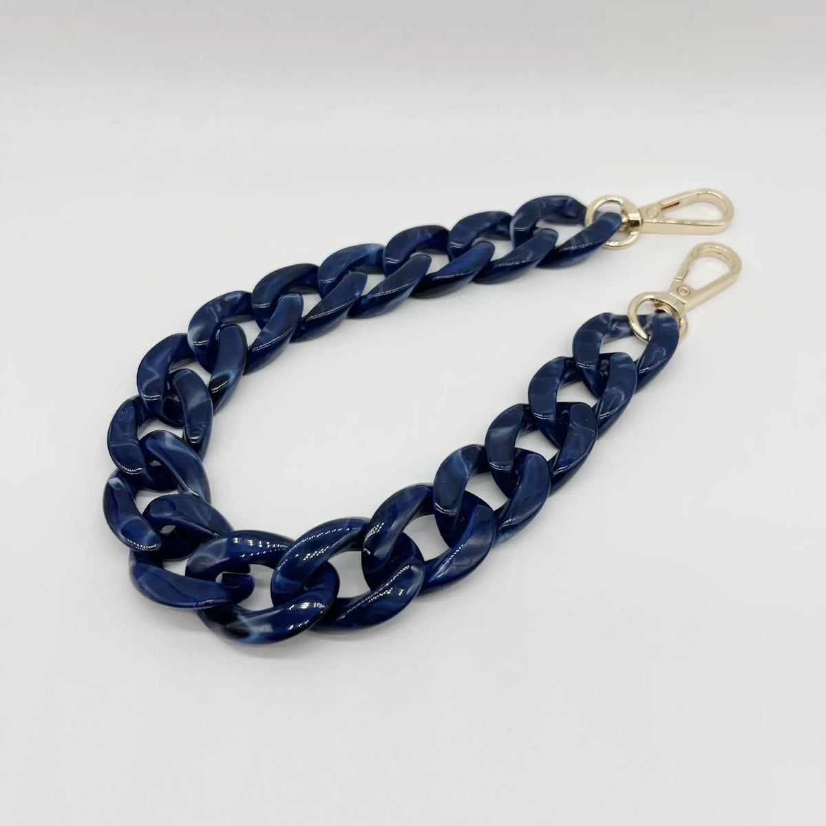 A dark blue acrylic chain bracelet with gold-colored clasps.
