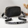 Black quilted camera bag with a gold strap and an attached wide black leather band featuring the text CITY AND LIFE KUCHEN NE
