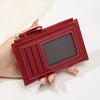 Gros plan d'un portefeuille en cuir PU marron avec fermeture éclair et fente rectangulaire, tenu dans une main.