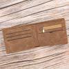 A brown slim leather wallet for men with a zippered coin pocket resting on a weathered wooden surface.