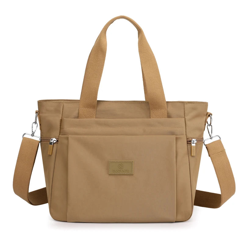 A tan nylon tote bag with brown straps and a secure zipper closure.