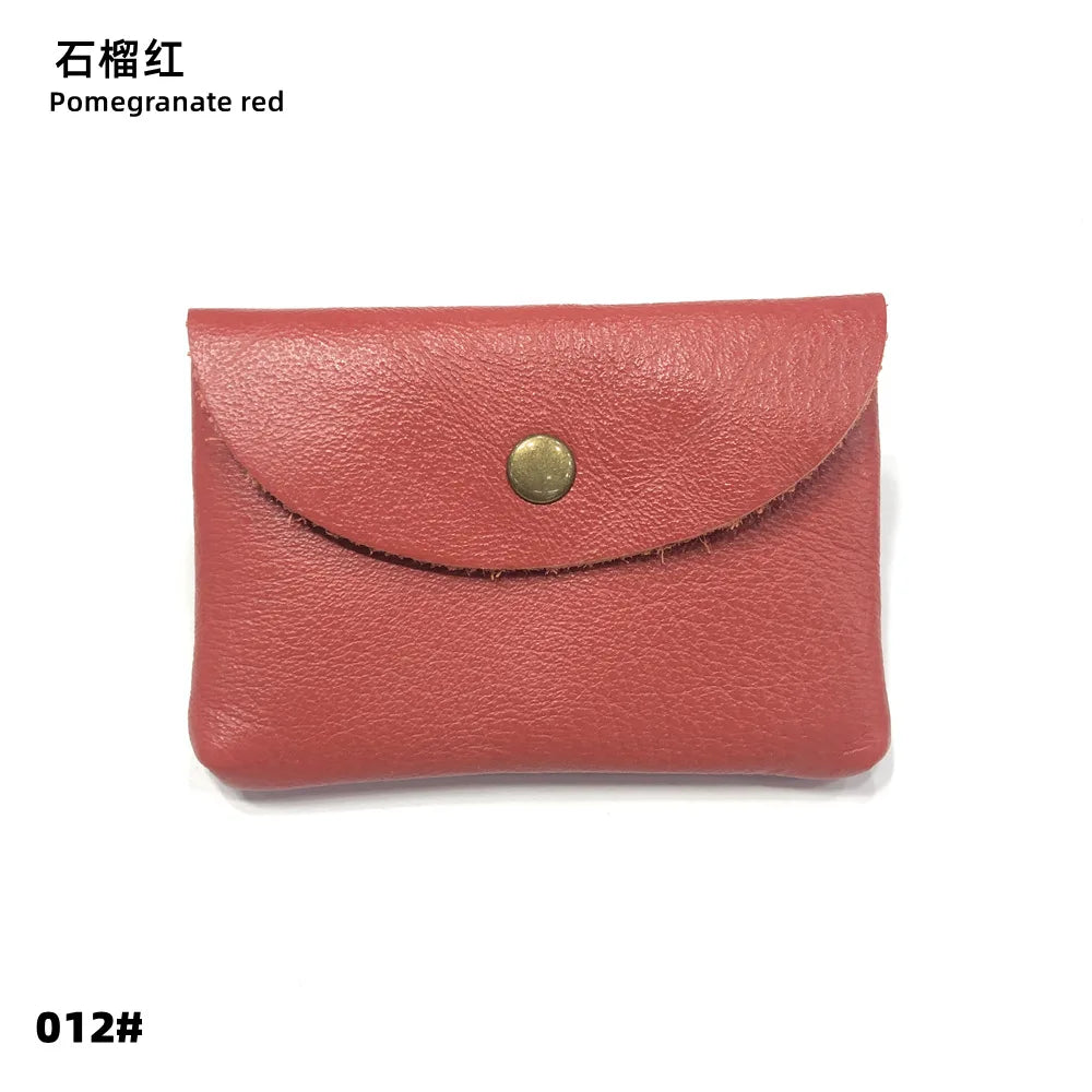 A terracotta red genuine leather card holder with a brass stud closure.