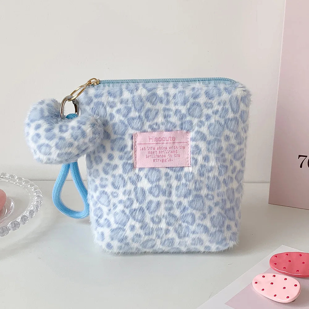 A light blue leopard print makeup bag with a fluffy trim and gold hardware.