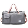 A gray travel duffle bag with pink straps and multiple pockets is shown from the front.