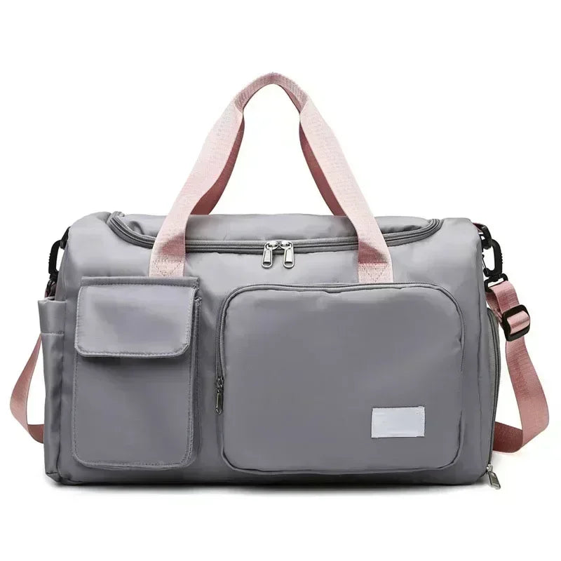 A gray travel duffle bag with pink straps and multiple pockets is shown from the front.