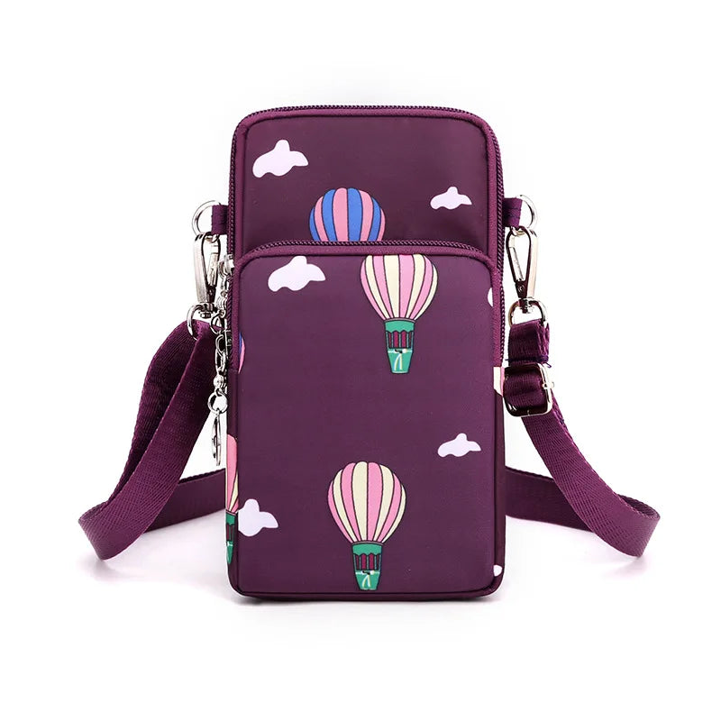 A purple nylon crossbody phone bag featuring white clouds and striped hot air balloons.