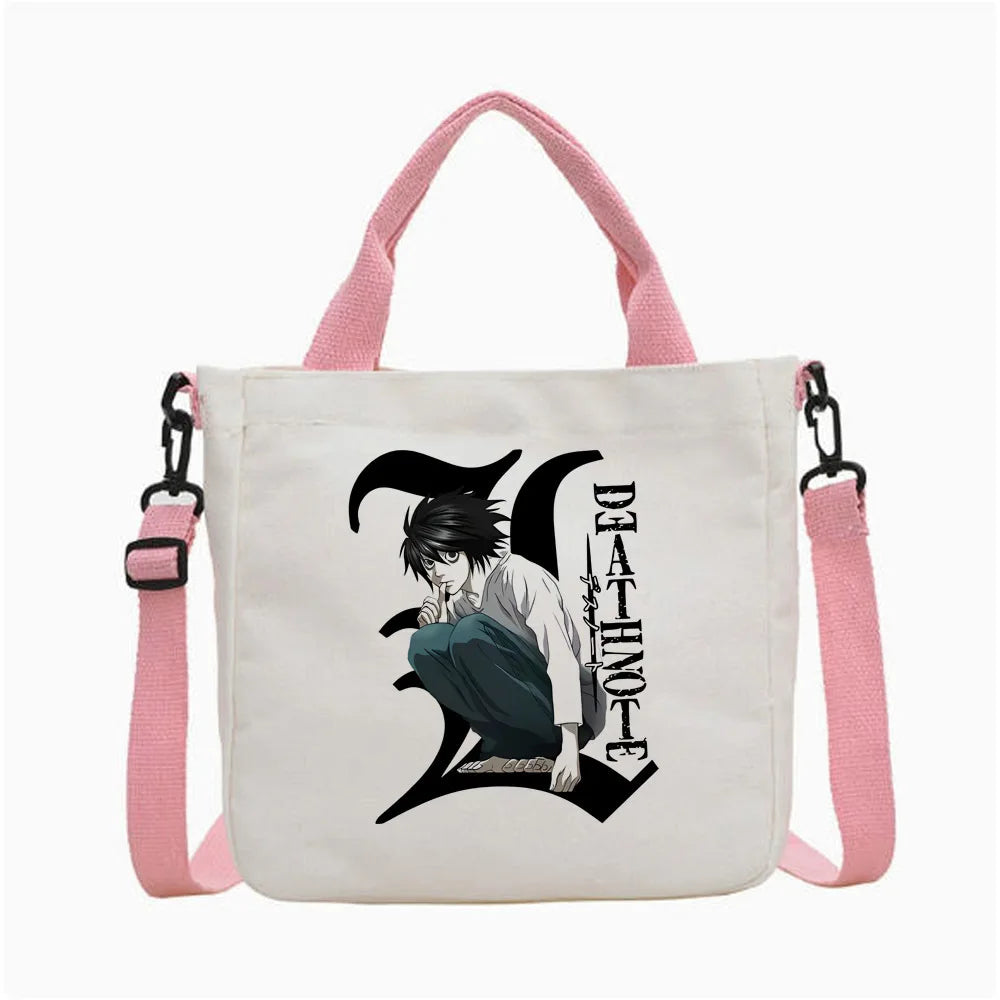 Bolso tipo tote blanco con gráfico negro de un personaje y el texto DEATHNOTE, sujetado por correas rosas.
