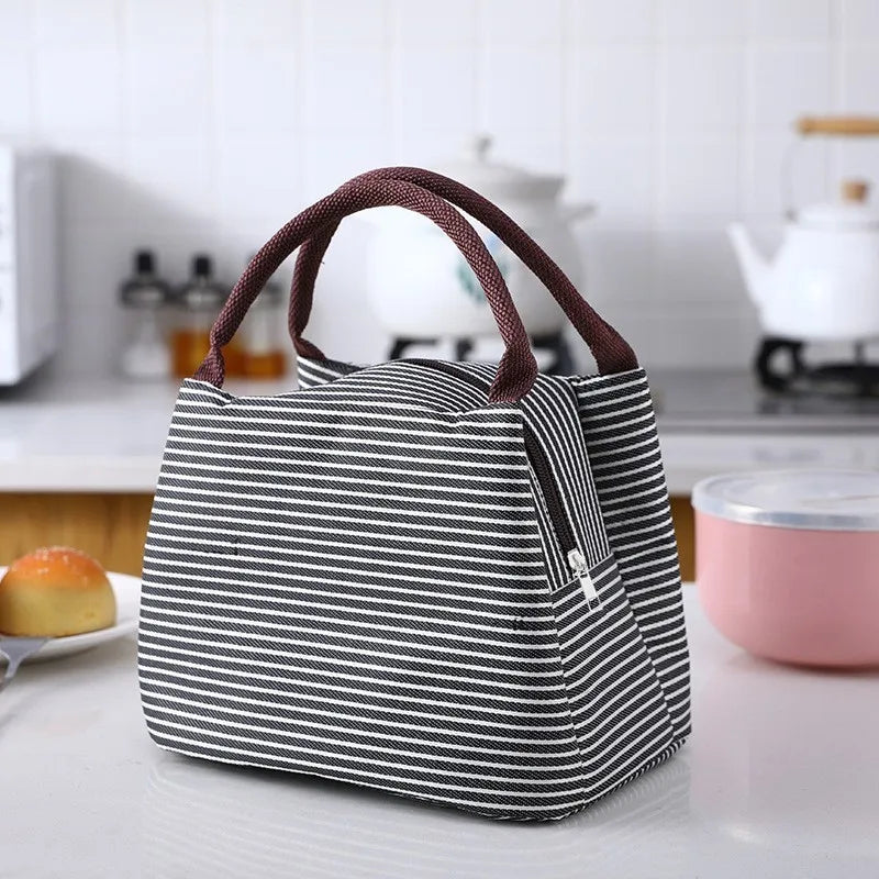 A black and white striped thermal lunch bag is displayed on a white surface.