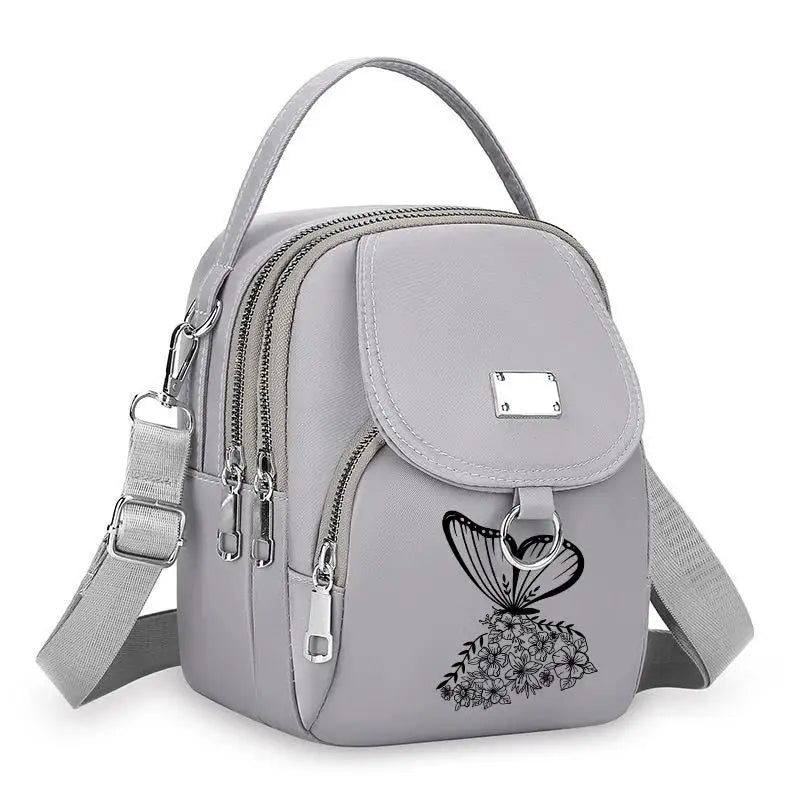 Sac bandoulière floral gris clair et durable avec fermeture éclair et sangle réglable.