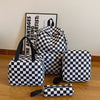 A black and white checkerboard multi-pocket backpack displayed on a wooden surface.