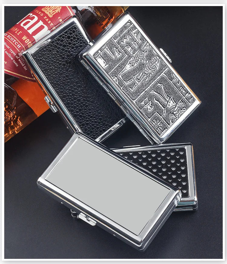 A collection of metal cigarette case holders and a box of tobacco products on a dark surface.