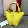 A bright yellow classic genuine leather bucket bag displayed against a neutral background.