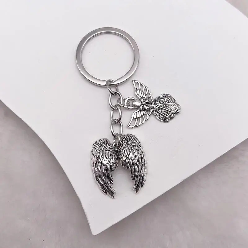 Silver metal angel wing keychain charm with a circular keyring